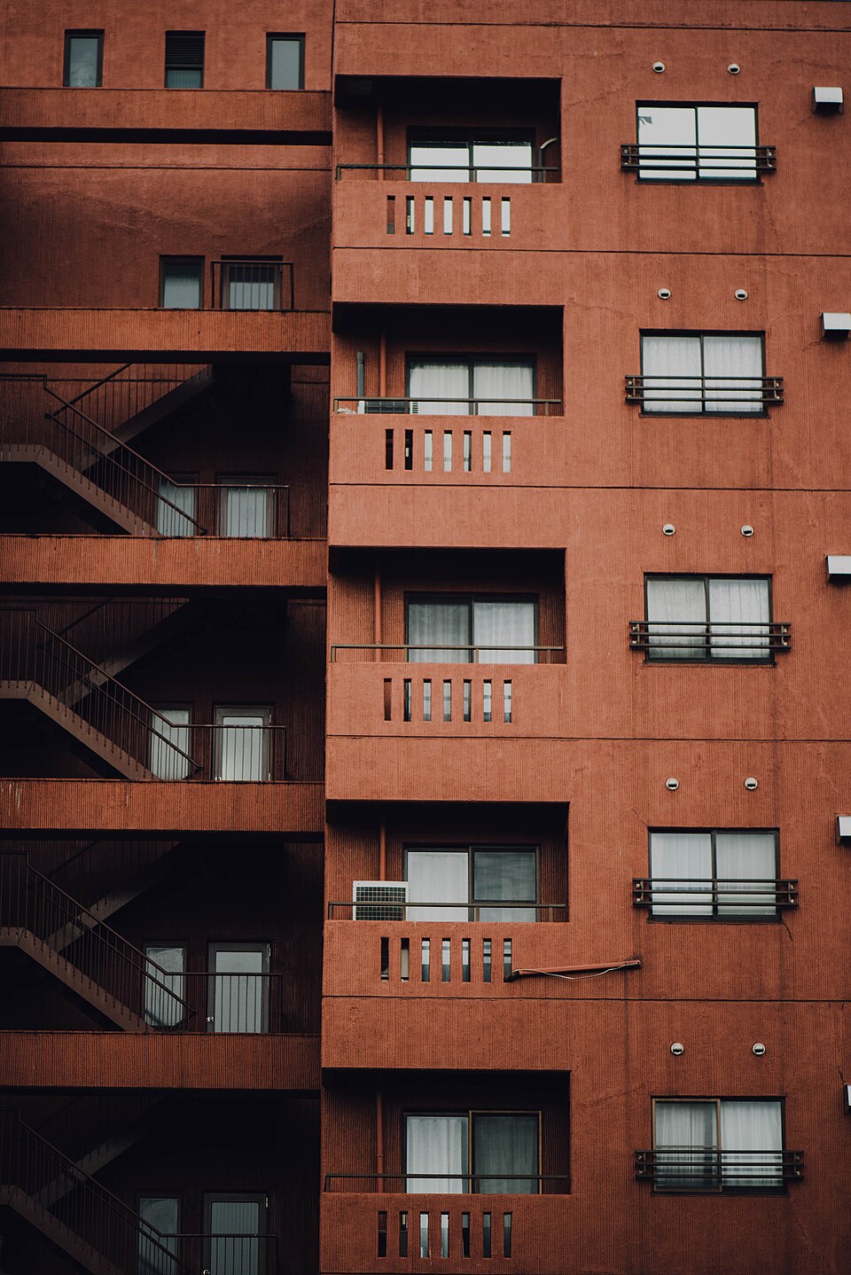 Fachada de prédio de apartamentos, com sacadas e escada externa